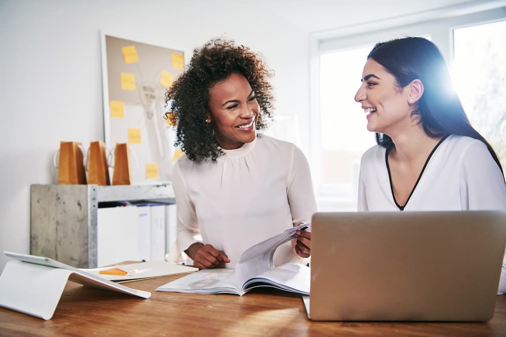 two-cheerful-businesswomen-at-laptop-with-document-2021-08-30-02-30-38-utc-2-op