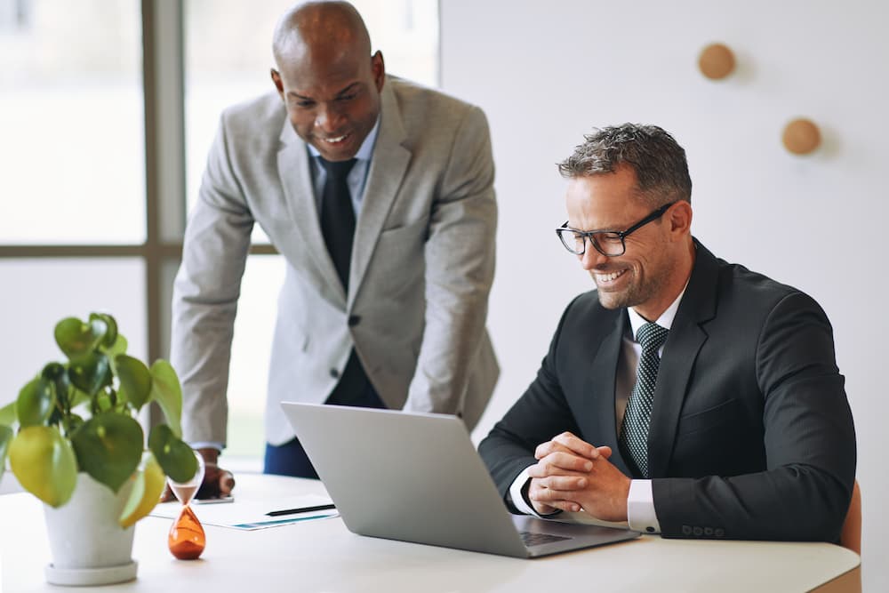 two-smiling-businessmen-talking-together-and-worki-2021-08-30-02-34-36-utc-2-op