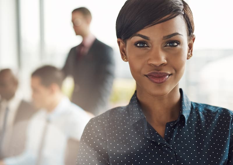 confident-business-woman-in-office-with-group-2021-08-26-17-26-58-utc-op